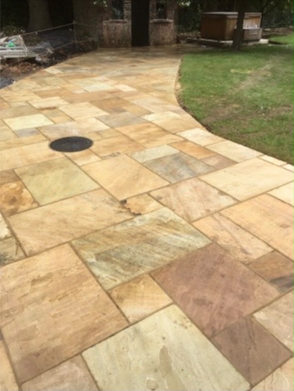 Finished sandstone patio with curved lawn edge